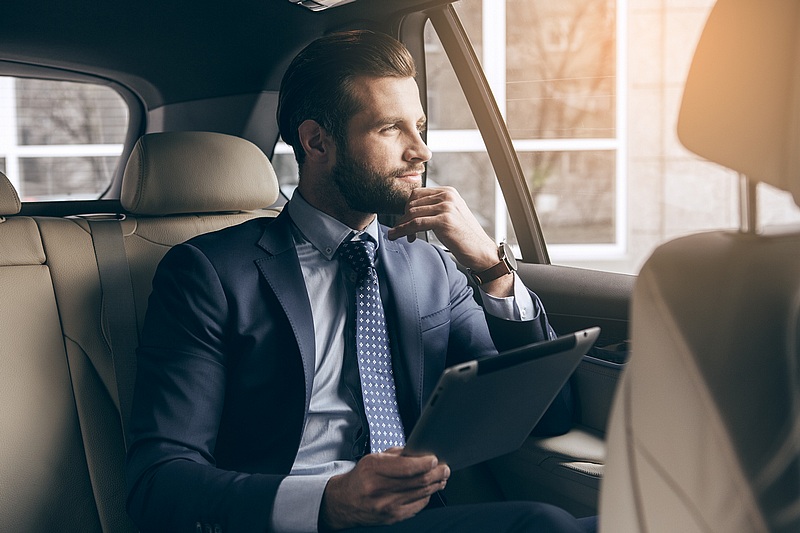 Executive traveling in the back of car seat